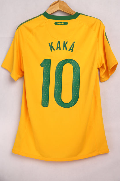 A short-sleeved soccer jersey in yellow with green accents, the number 10 and the name 'KAKA' printed on the back. Brazil 2010 home shirt kit jersey Kaka #10 size S Nike football soccer